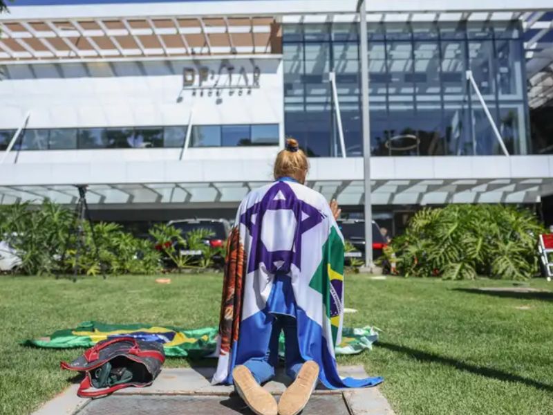 Apoiadora ora em frente a hospital onde Bolsonaro está internado
